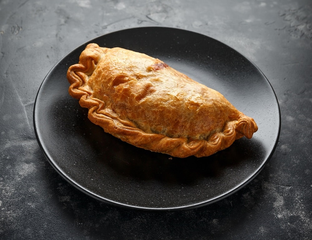 A pasty on a black plate